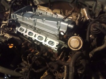 I felt terrible installing the freshly overhauled Cylinder Head, new valves, every inch cleaned, fresh paint, etc in that filthy bay, but since the car came to me with a loose head (it wasn't off, but was loose), I couldn't risk washing it and getting water in the block... but it WILL get cleaned! Fresh silicone hoses may be in order too, and upgraded aluminum coolant pipe fittings, to do away with the plastic trash.